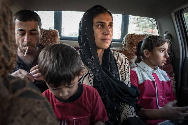 Mutter Jaleelazusammen mit ihren Kindern Khairi und Marya auf dem Weg nach Arbil. Ihr Mann Hazm begleitet sie zum Flughafen