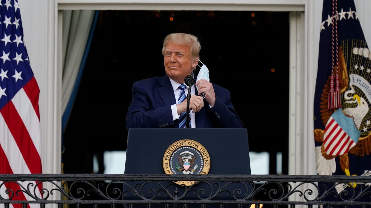 USA, Washington: Donald Trump, Präsident der USA, steht auf dem Balkon des Weißen Hauses und nimmt seinen Mund-Nasen-Schutz ab, um zu seinen Unterstützern zu sprechen, die sich auf dem Südrasen versam